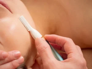 Dermaplaning Facial — therapist dermaplaning a client's face