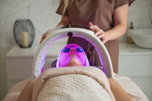 LED Light Therapy Facial — a therapist giving a client an LED Facial