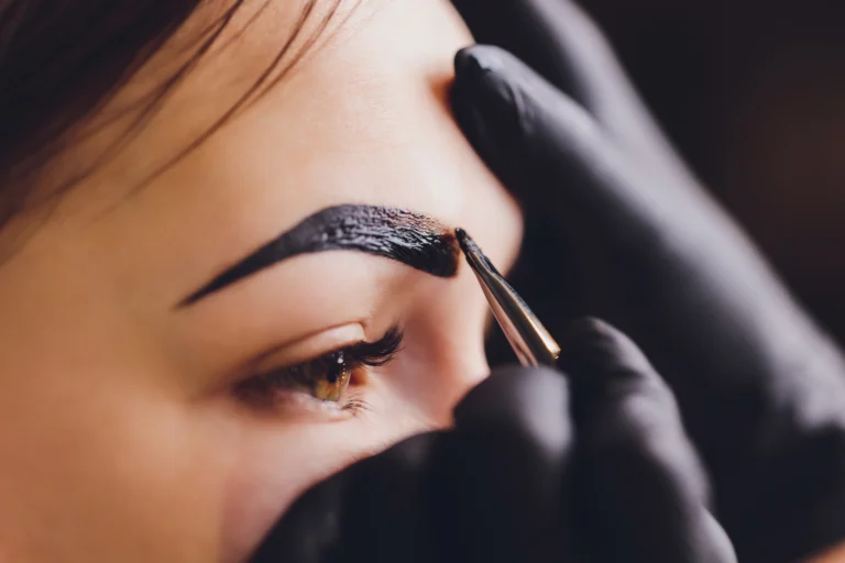 Henna Brows — a therapist applying henna brow tint on a client