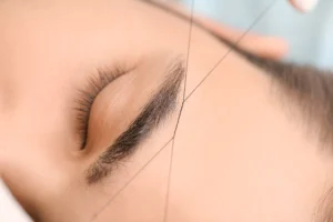 Threading Services — brow specialist threading a client's eyebrows
